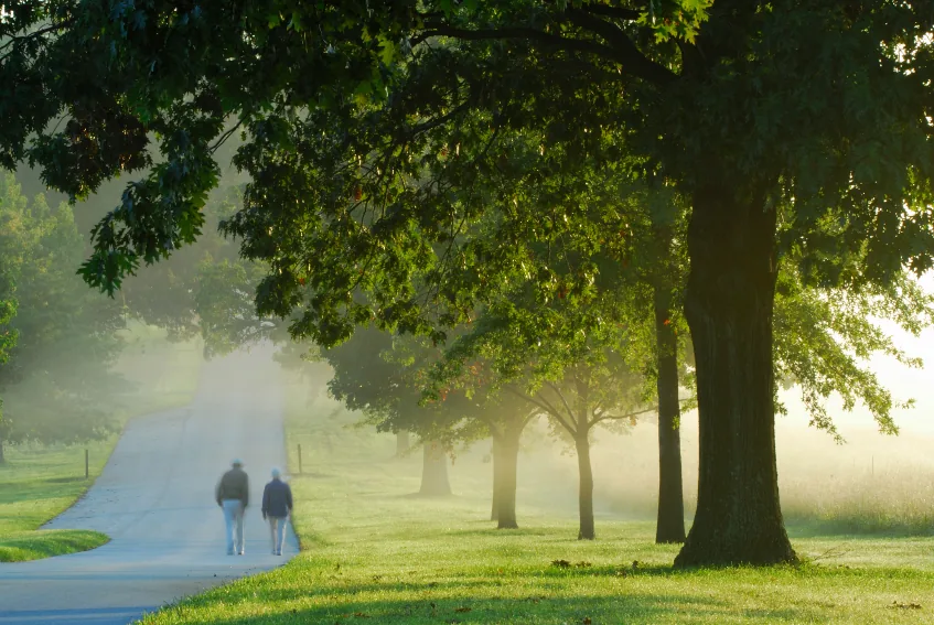Caring Hearts caregiver walking with a senior client outdoors